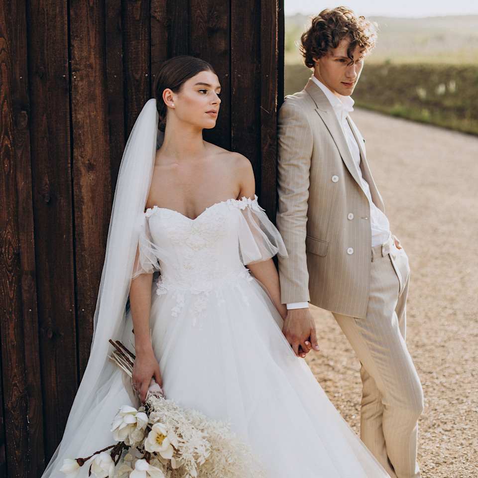 Braut und Bräutigam in einem beigen Anzug 