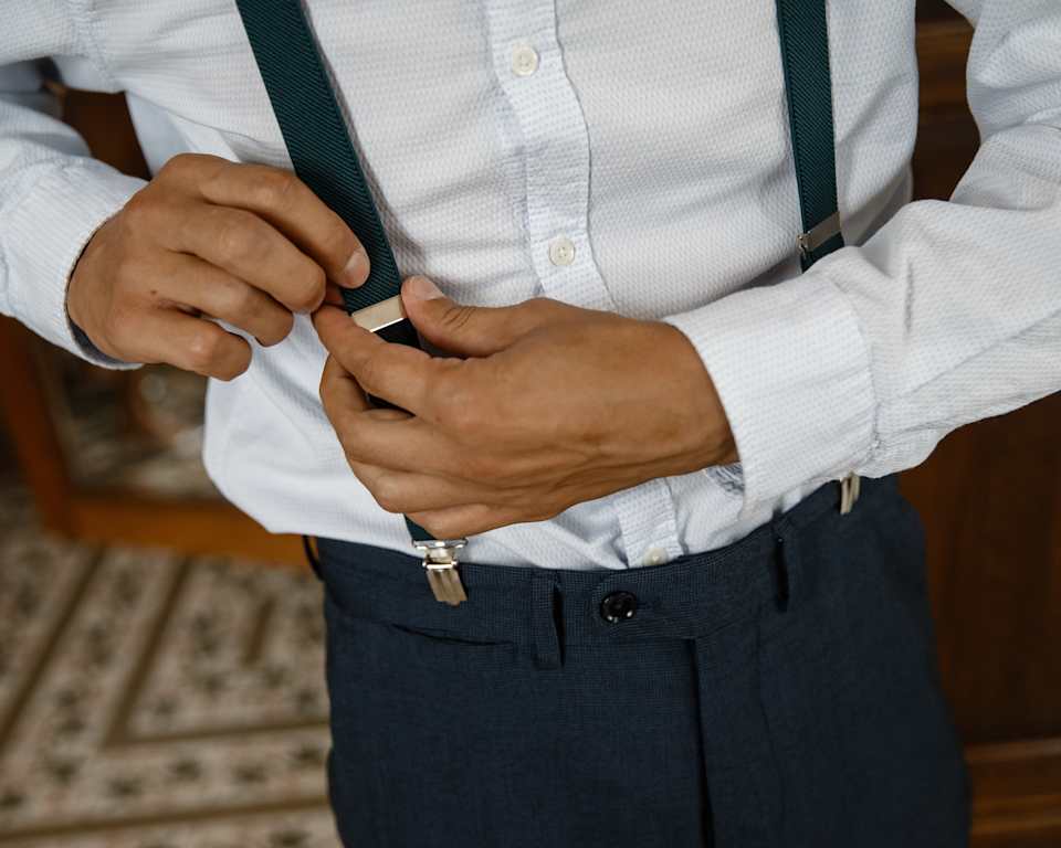 Nahaufnahme von einem Mann der sich die Hosenträger zumacht