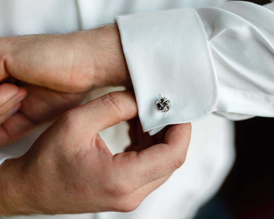 Nahaufnahme Mann knöpft sich Manschettenknöpfe zu