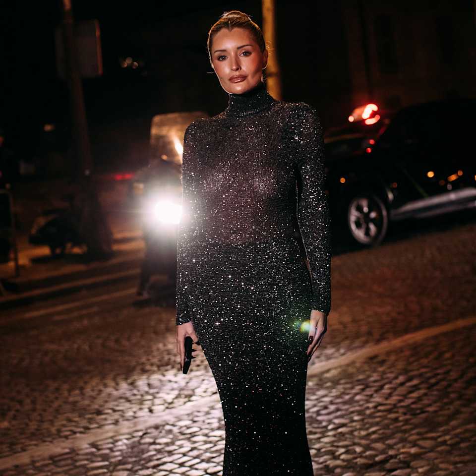 Blonde Frau trägt schwarzes enges Kleid mit Glitzer