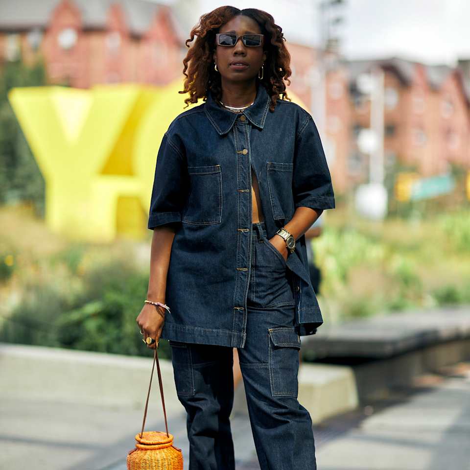 Frau trägt ein Set aus Jeansbluse und Jeanshose in einem dunkelblauen Denim
