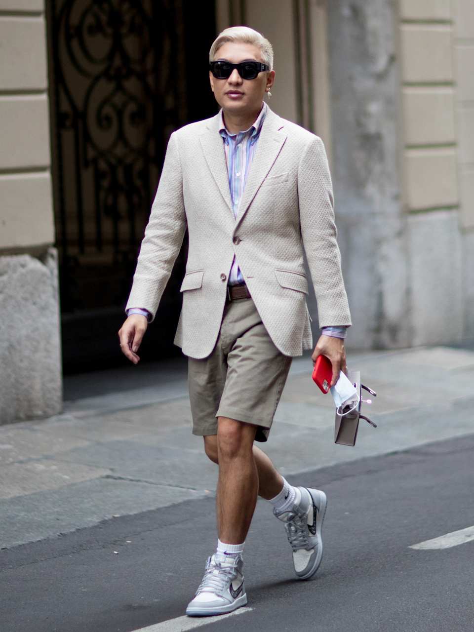 Mann trägt ein helles Leinensakko zu einer grauen Shorts und Sneaker