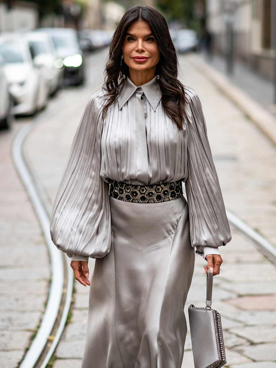 Frau trägt ein Seidenbluse und einen Seidenrock in der Farbe Silber 