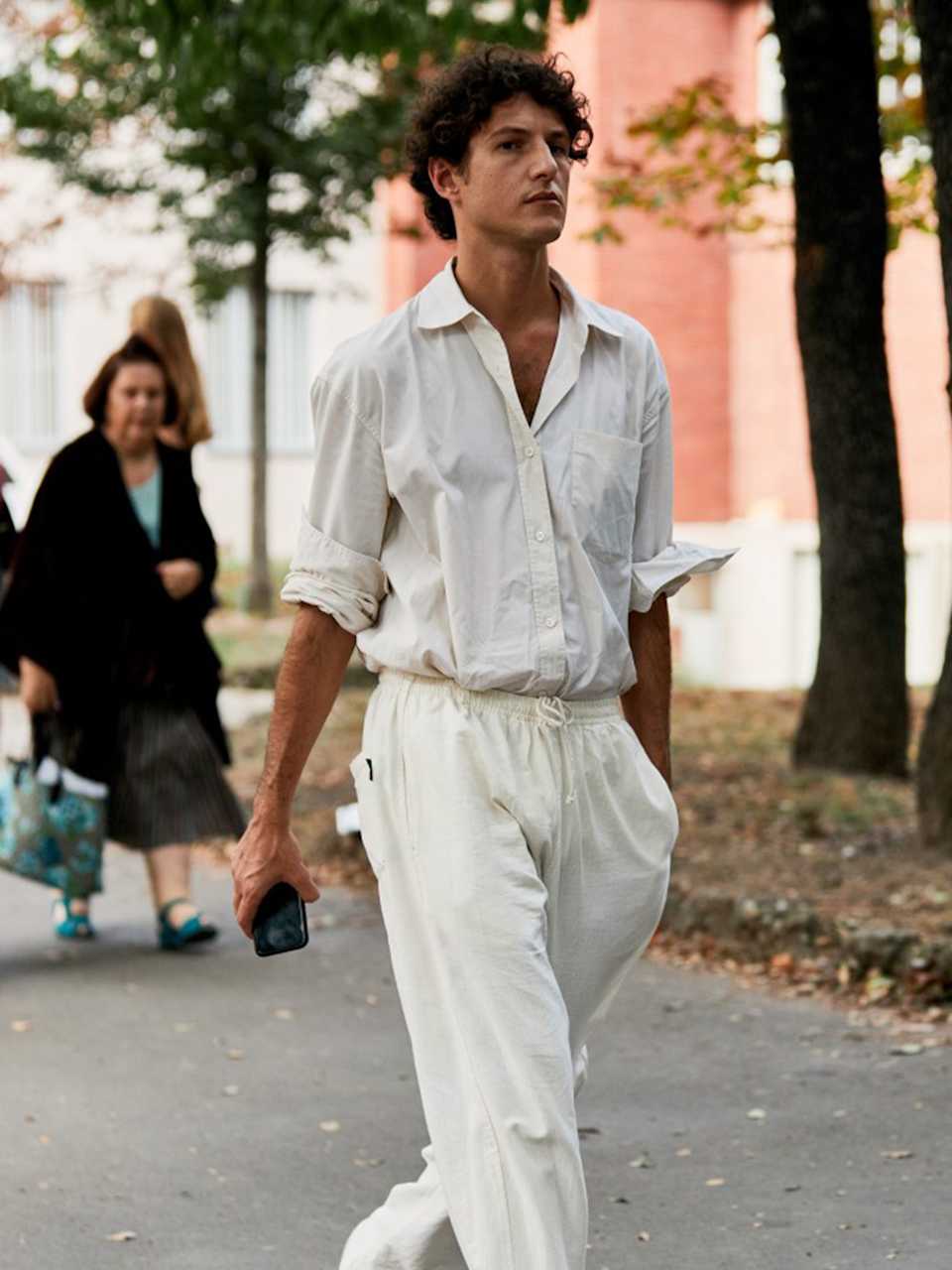 Mann trägt ein Set aus Hemd und Stoffhose in der Farbe Weiß 