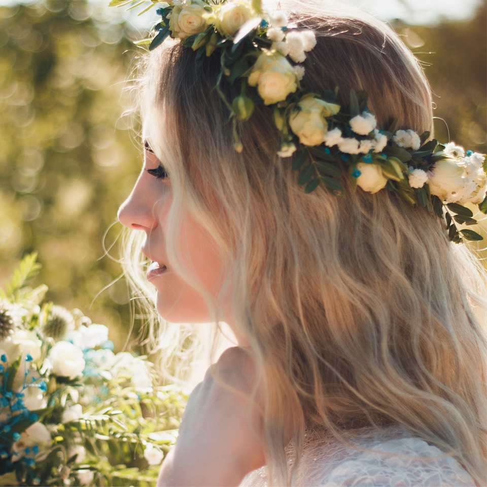 Braut mit Beach-Waves und einem Blumenkranz