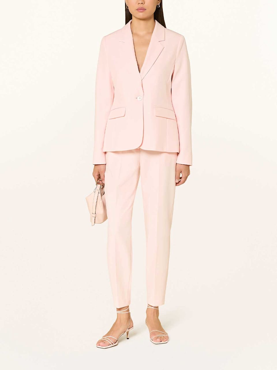 Frau trägt einen rosafarbenen Hosenanzug