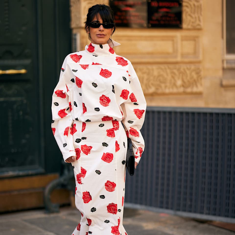 Frau trägt ein weißes Kleid mit roten Blütenmuster