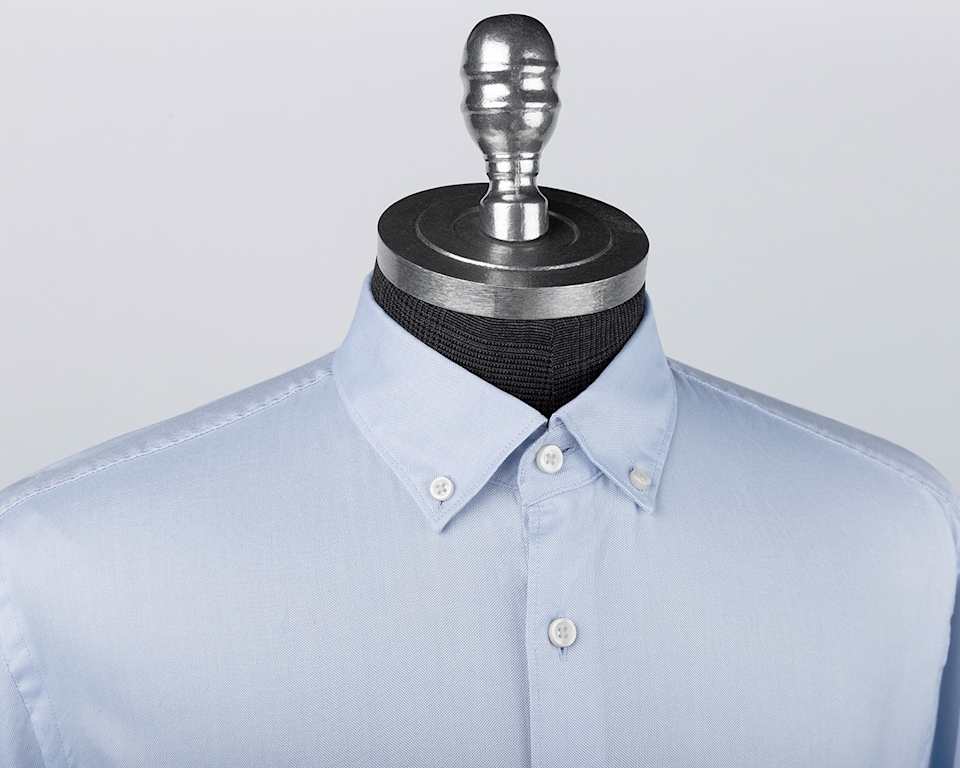 Ein hellblaues Hemd mit Button-Down-Kragen auf einer Schneiderpuppe.