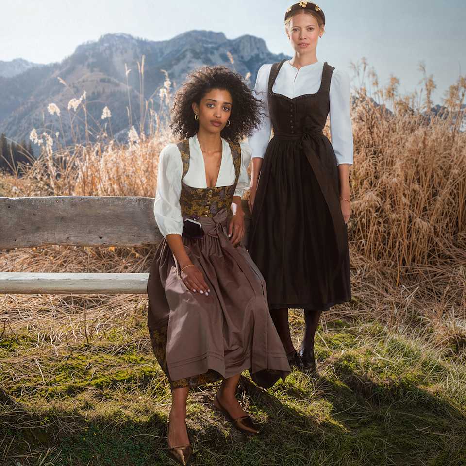 Zwei Frauen tragen zwei Dirndl in braunen Erdtönen