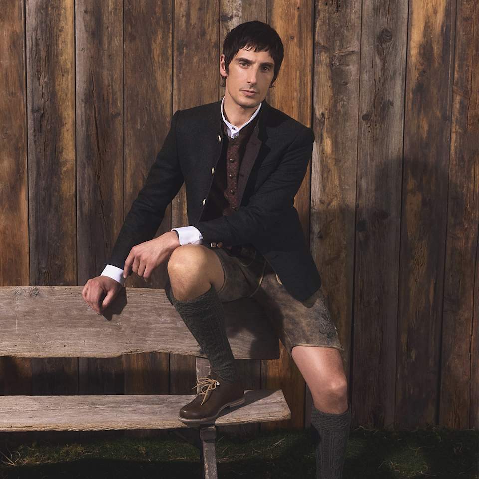 Mann trägt Trachten-Outfit mit Lederhose