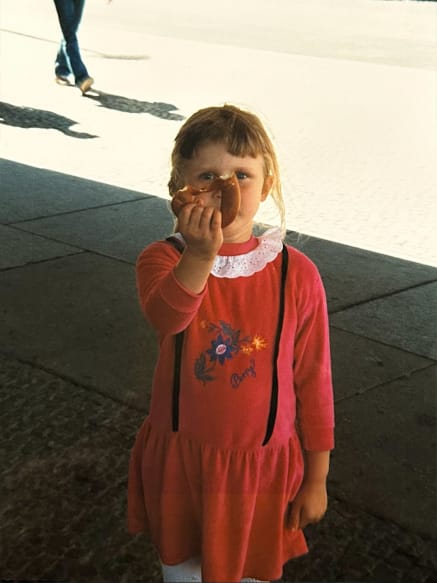 Foto eines Kindes, das eine angebissene Brezel in die Kamera hält