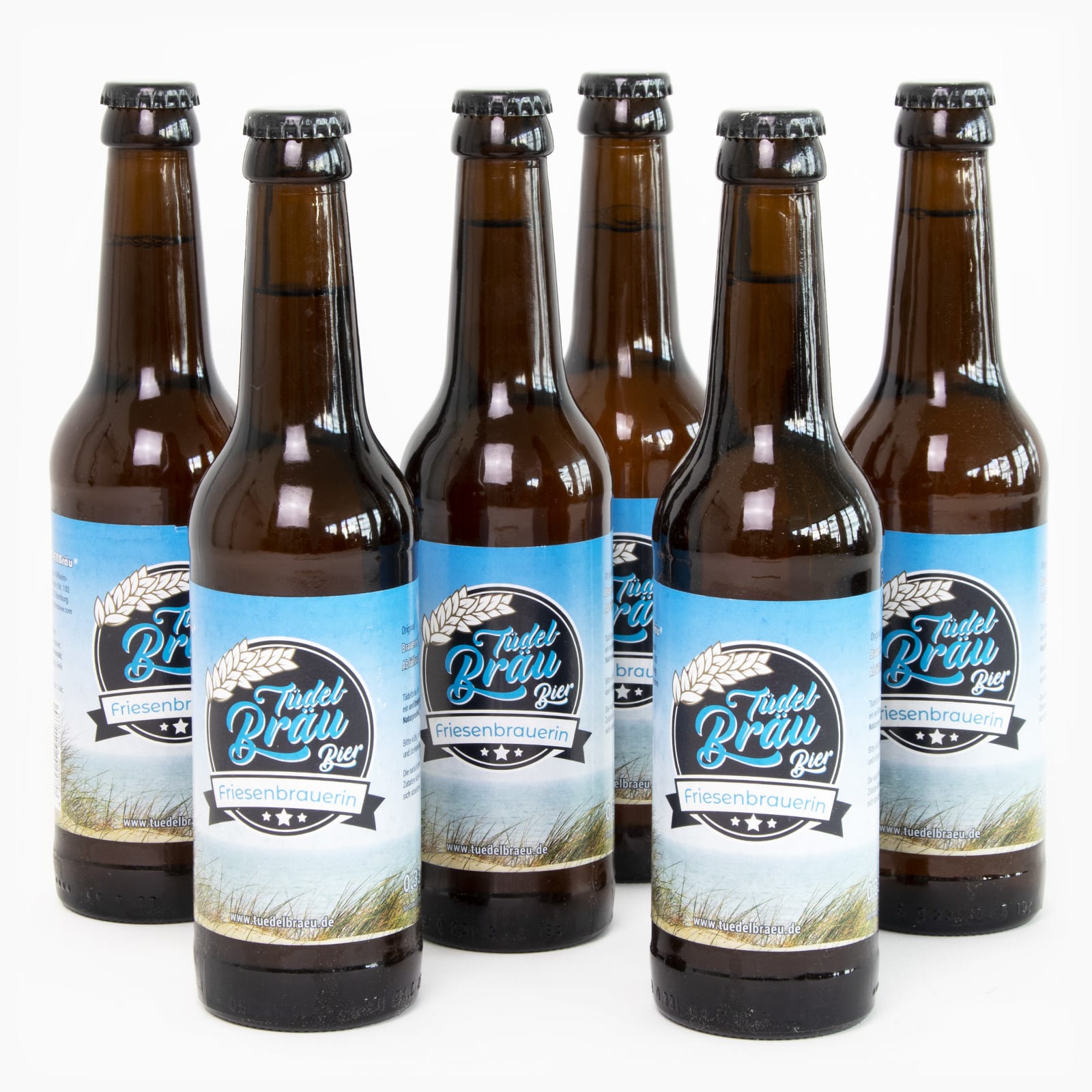 Sechs Bierflaschen der Marke Tüdelbräu stehen nebeneinander. 