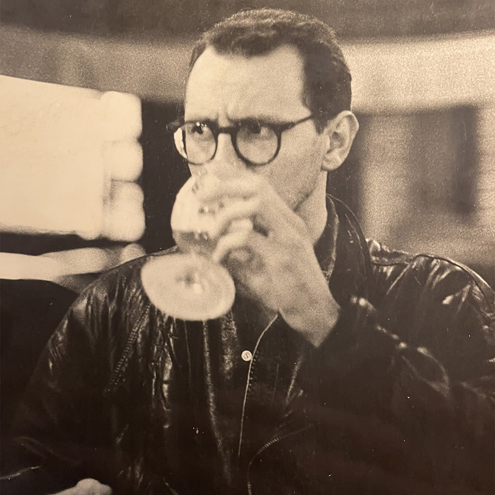 Ein junger Andreas Pflüger trinkt aus einem Bierglas, Foto in Sepia