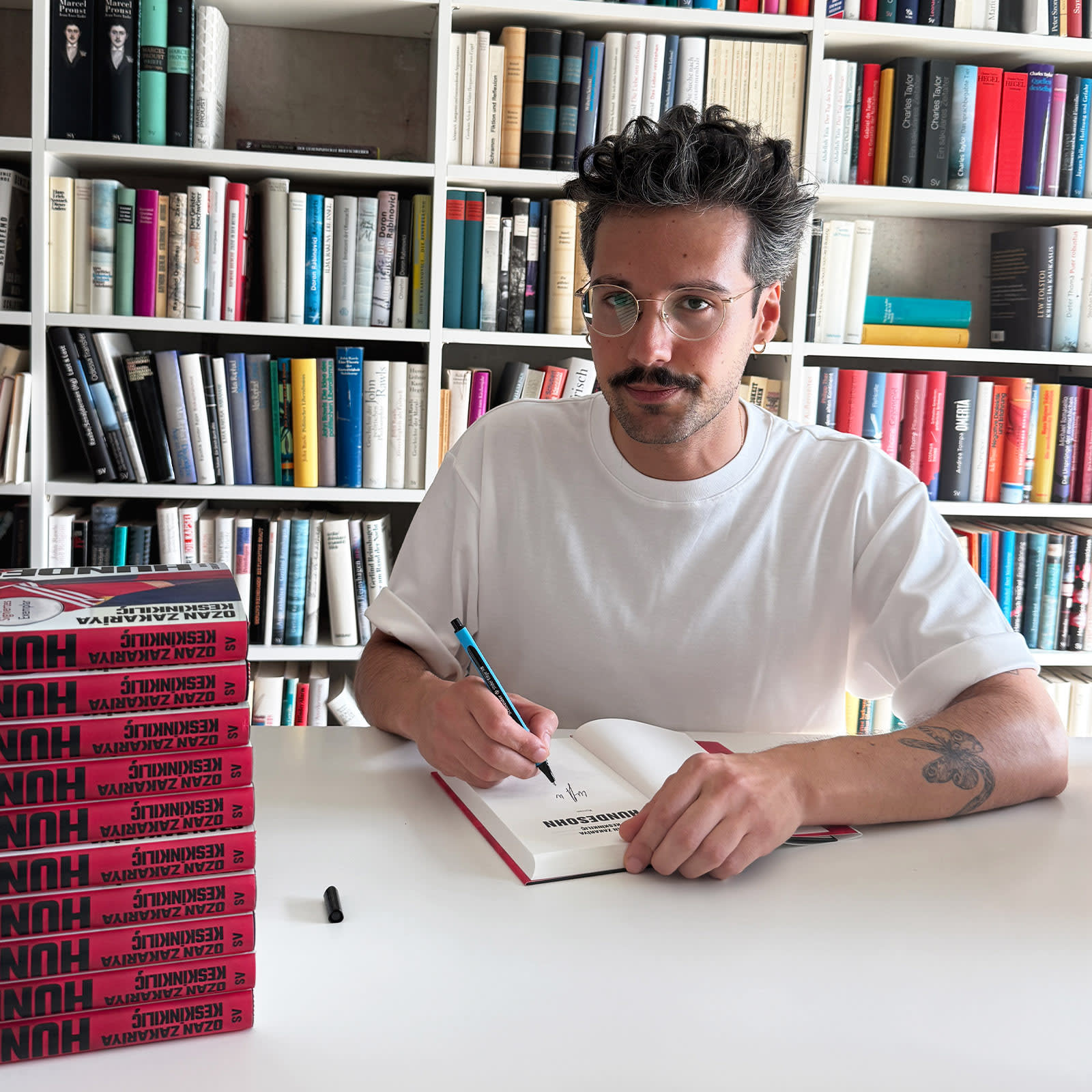 Der Autor sitzt mit am Tisch und signiert sein Buch »Hundesohn«