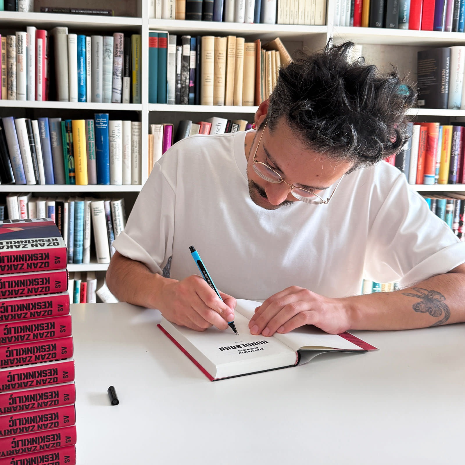 Ozan Zakariya Keskinkılıç signiert sein Buch »Hundesohn«