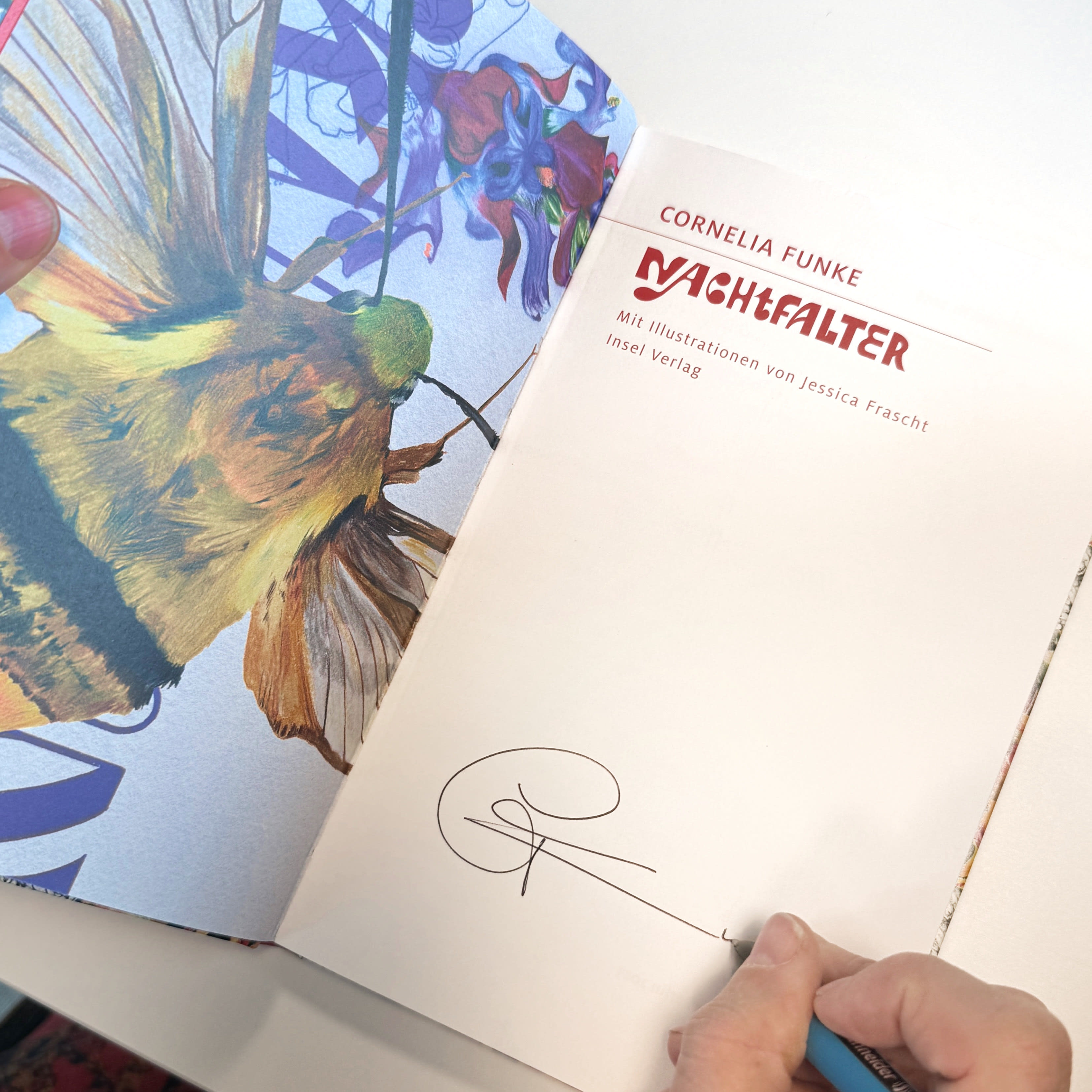 Ein Foto von einem aufgeschlagenen Buch mit der Unterschrift von Cornelia Funke.