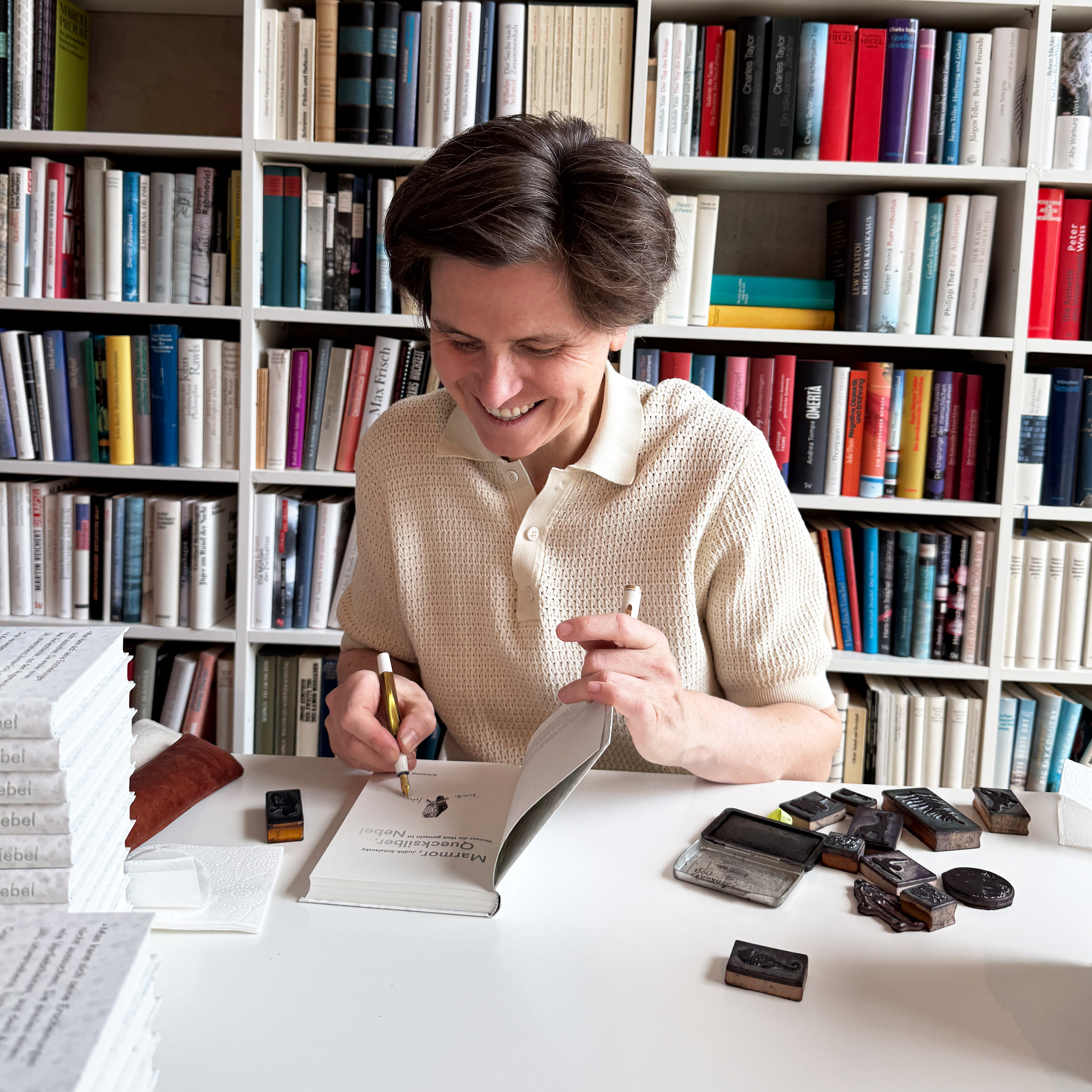 Ein Foto von Judith Schalansky beim Signieren ihrer Bücher.