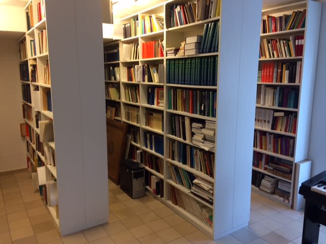 Drei weiße deckenhohe Bücherregale hintereinander