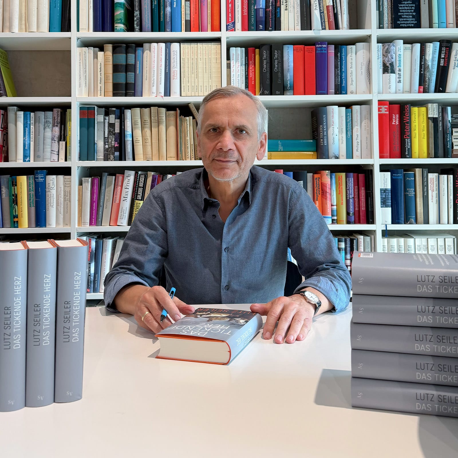 Der Autor Lutz Seiler signiert Exemplare seines Buches "Das tickende Herz"