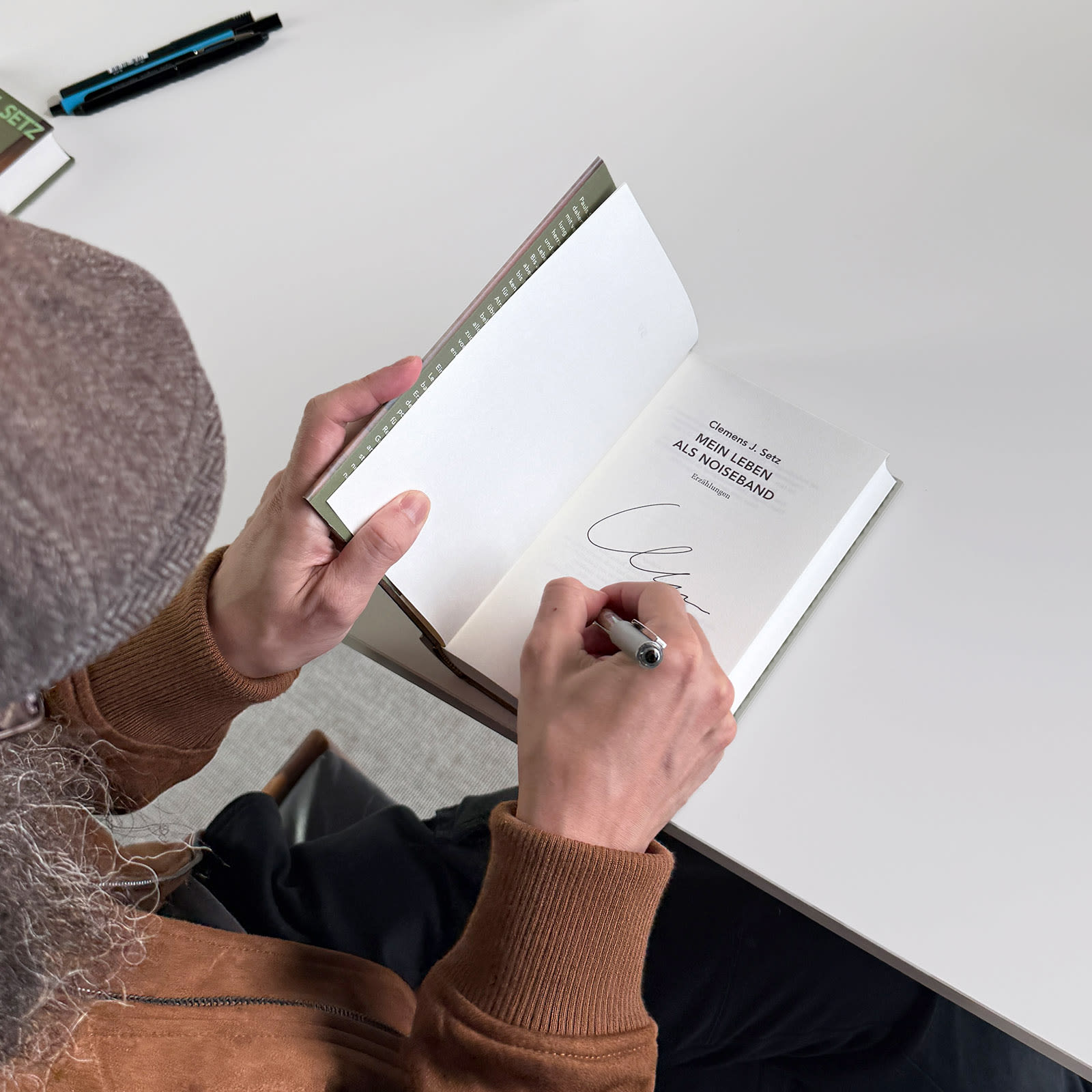 Der Autor Clemens J. Setz signiert sein Buch "Mein Leben als Noiseband"