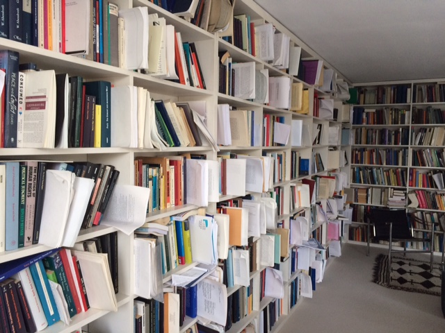 Weißes Bücherregal mit Büchern und Zetteln