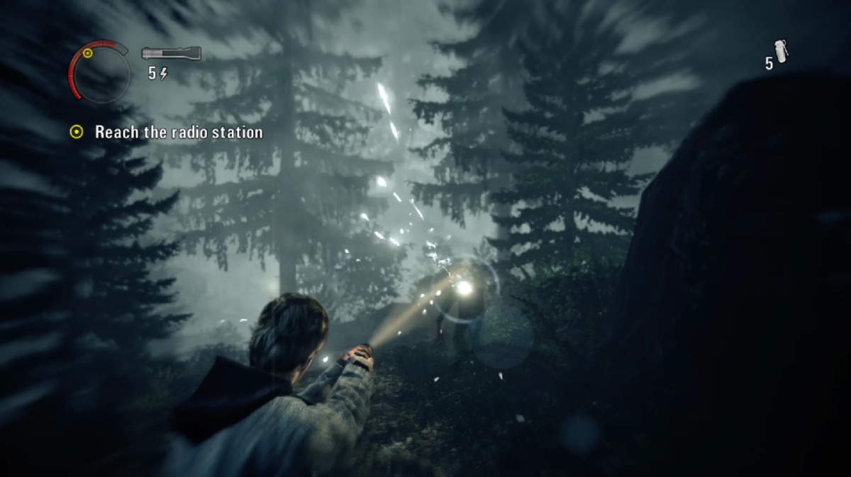Alan Wake focusing a flashlight on a Taken with battery, ammunition and objective indicators visible
