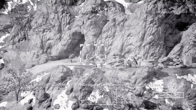 The Apache’s monochrome TADS view centres a targeting box on an armed position in the mountains.