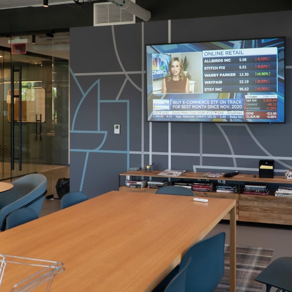 Open office seating area with office wall graphics displaying abstract map linework on gray painted walls as environmental branding.