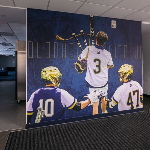 Team photo locker room wallpaper showing three players in action on blue textured background as freestanding divider.