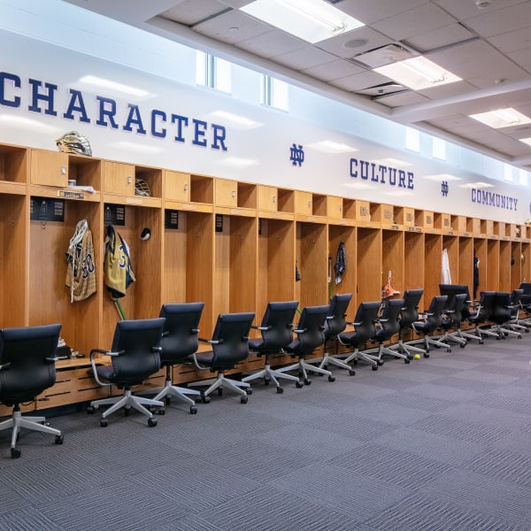 Dimensional lettering reading 'Character,' 'Culture,' and 'Community' in navy on white wall above wooden locker cubbies.
