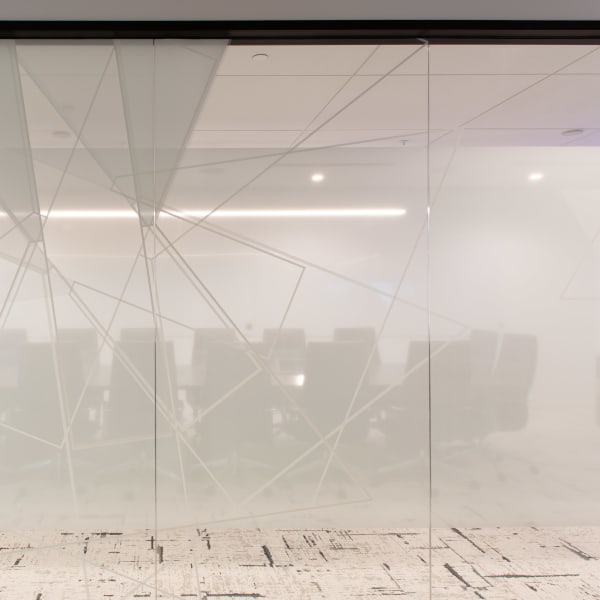 Office glass frosting on large meeting room walls showing geometric line pattern for privacy.