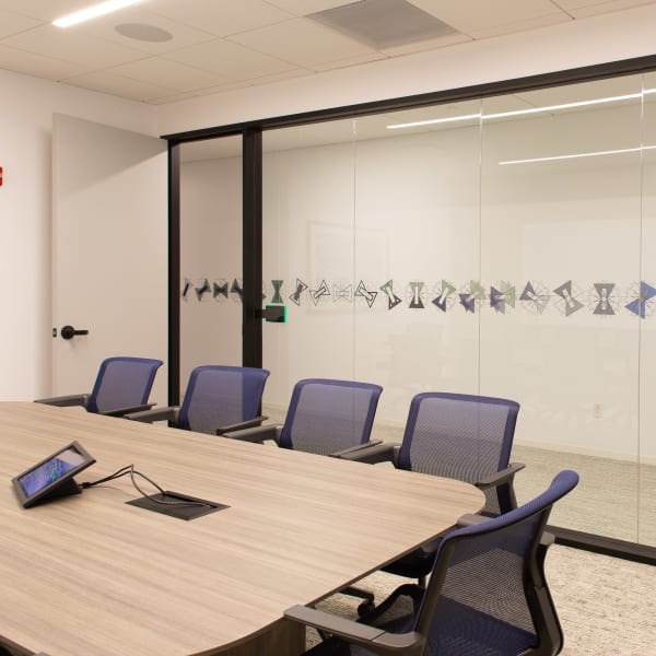 Office glass frosting on large meeting room wall featuring horizontal geometric shapes for privacy.