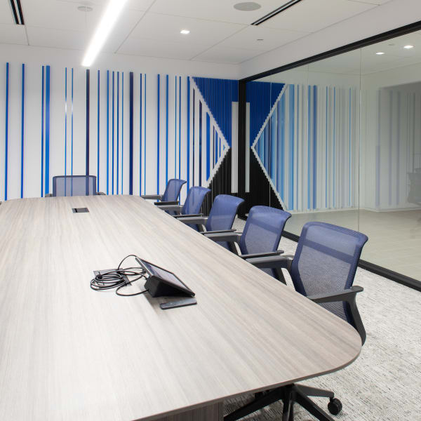 Environmental branding featuring vertical striped wall graphics with central logo in conference room.