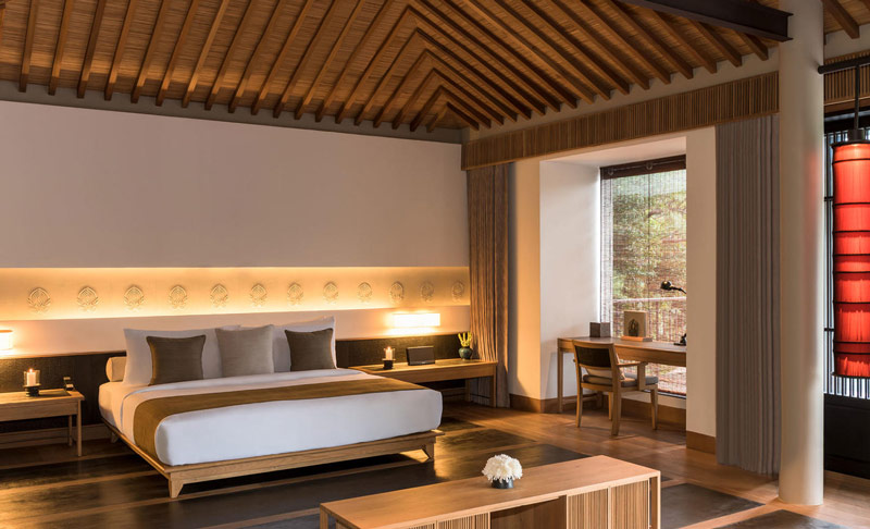 Phòng ngủ tại Amanoi với trần gỗ teak và nội thất tối giản