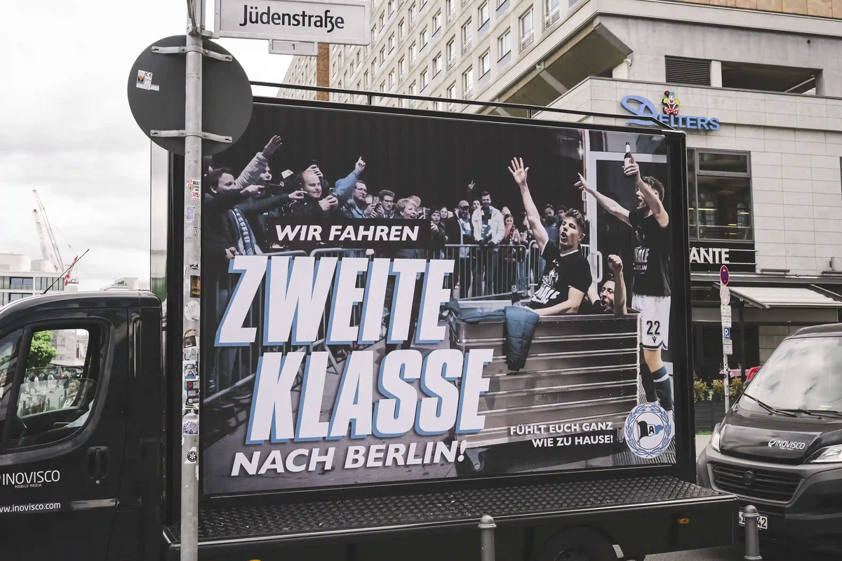 Ein Plakatwagen mit einem Kampagnenmotiv unterwegs auf den Straßen von Berlin während des Pokalfinales 2025 mit Arminia Bielefeld