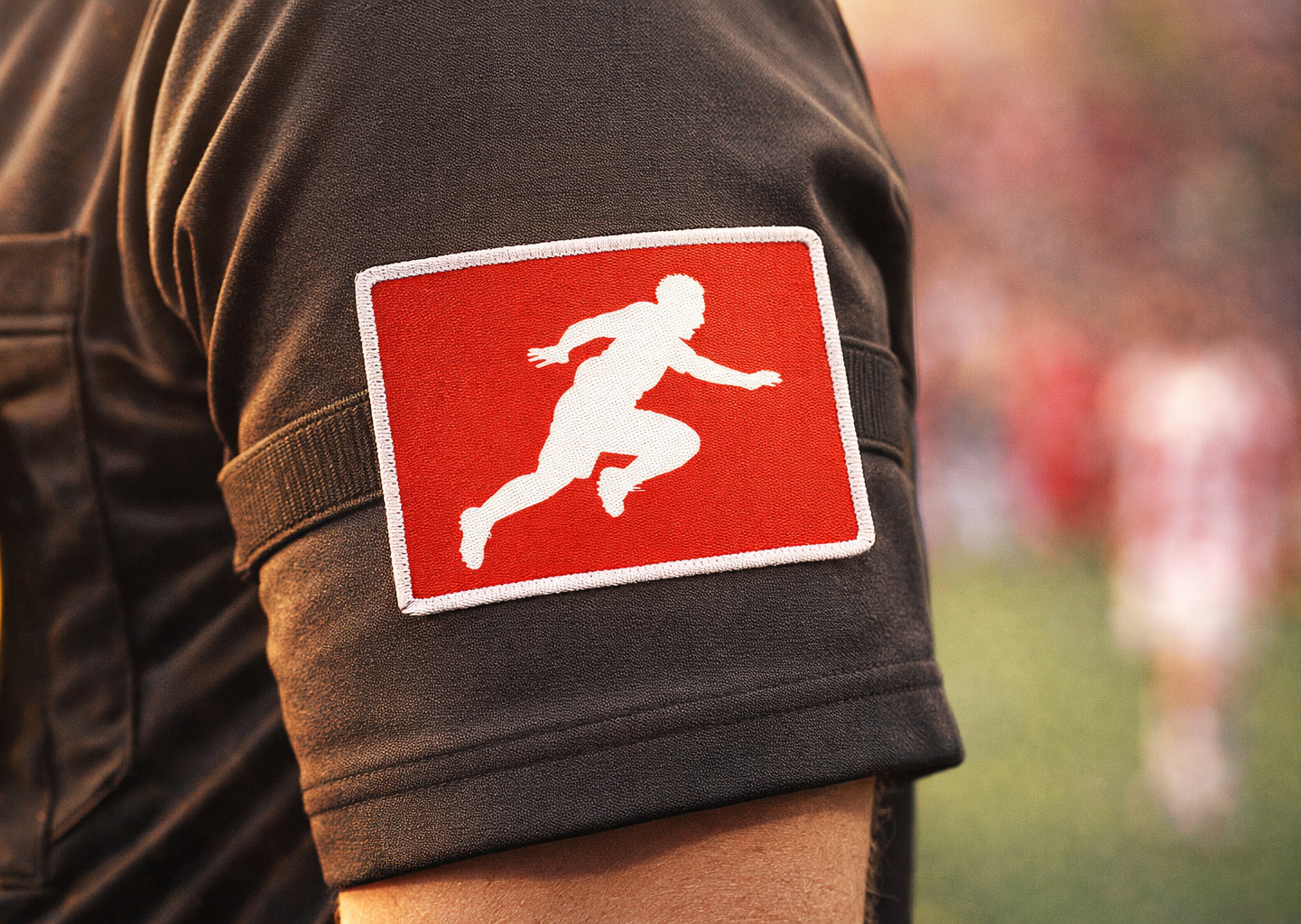 Auf dem Logo ist die typische Bewegung eines Fußballspielers zu sehen, der bewusst den Kontakt zu einem Gegenspieler sucht. Stilisiert und in abstrakter Form.