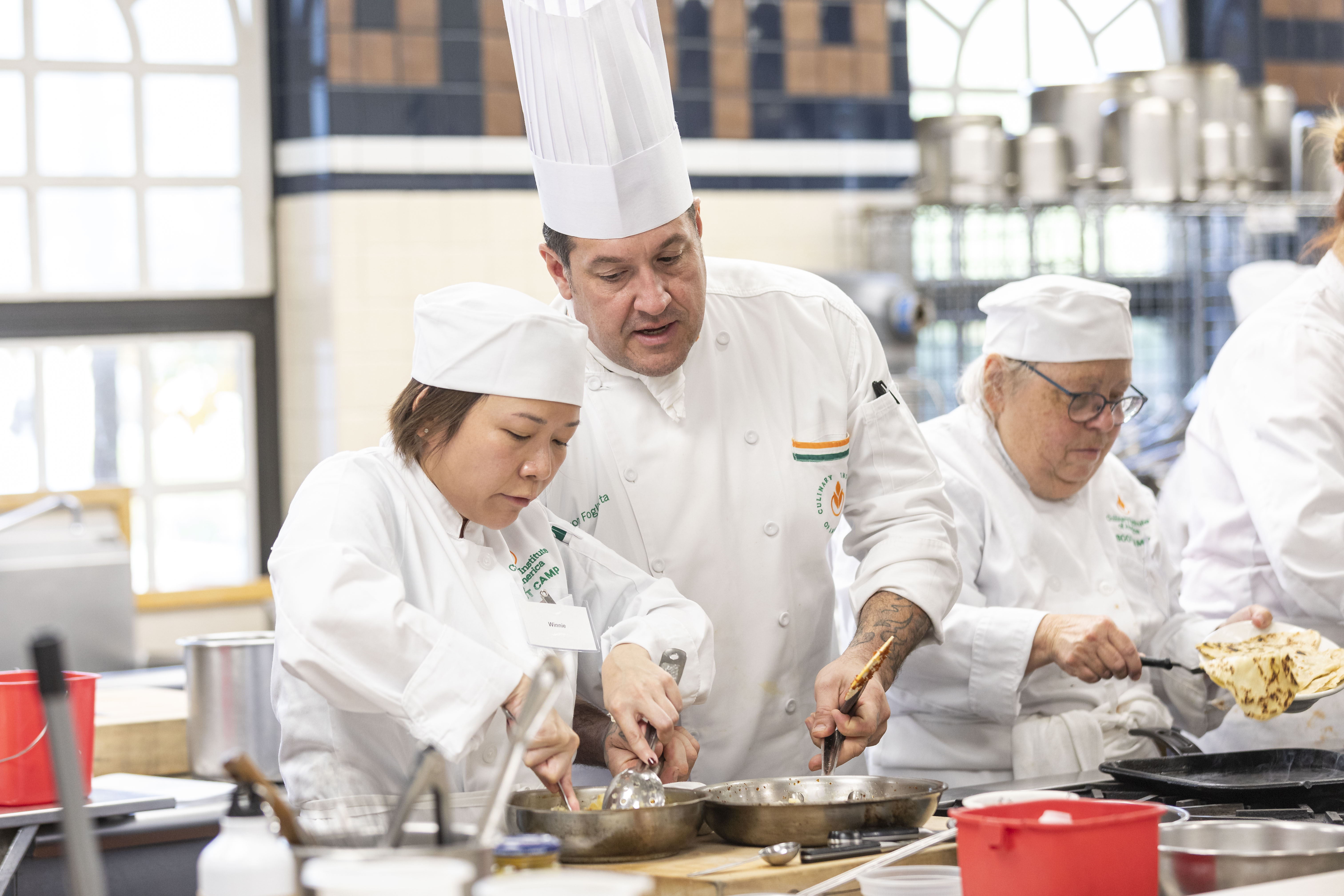 Chefs in kitchen teaching and learning.