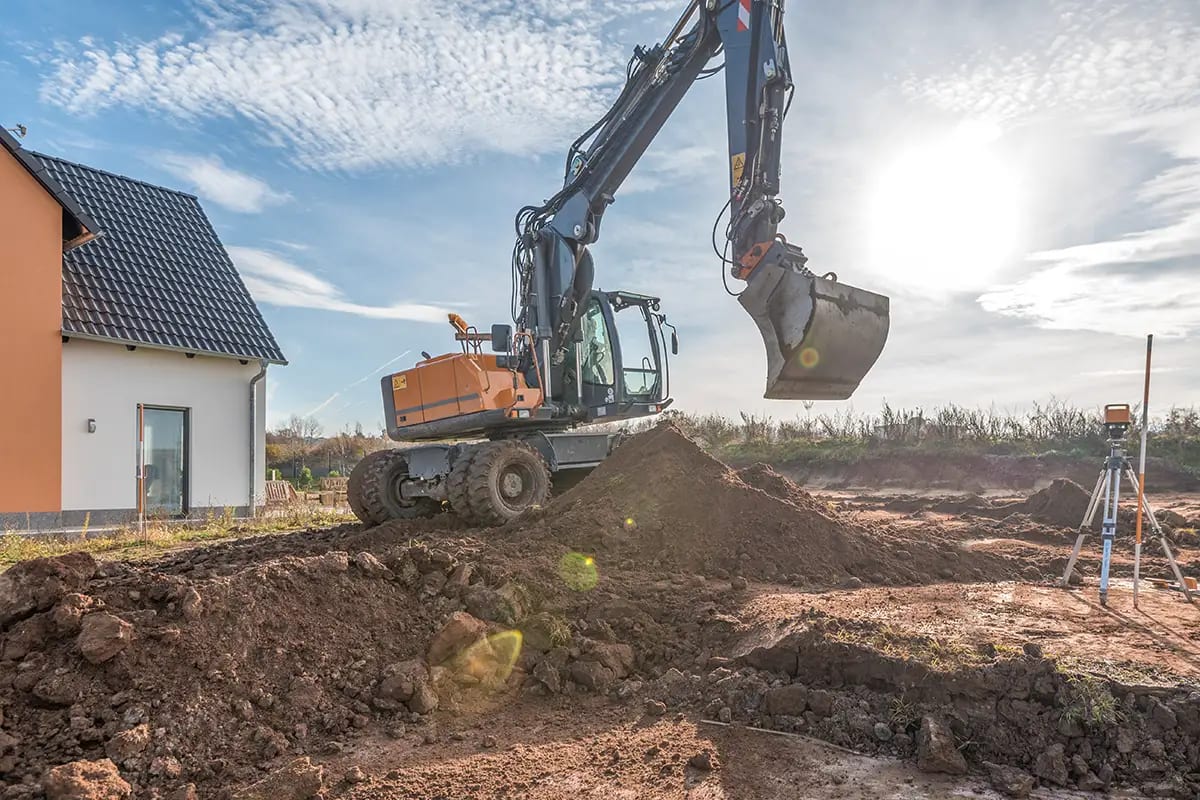 Bagger beim Erdaushub während des Hausbaus