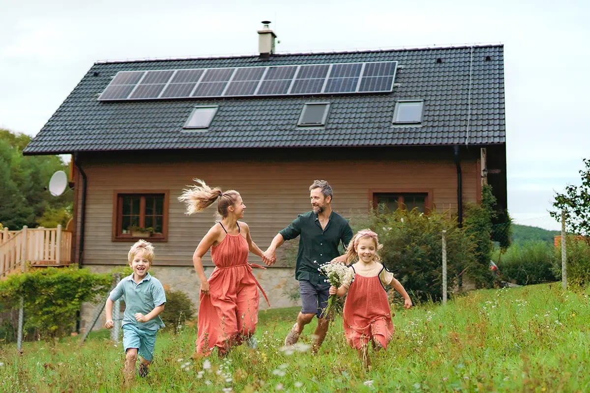Familie im Garten vor ihrem Haus mit Photovoltaik
