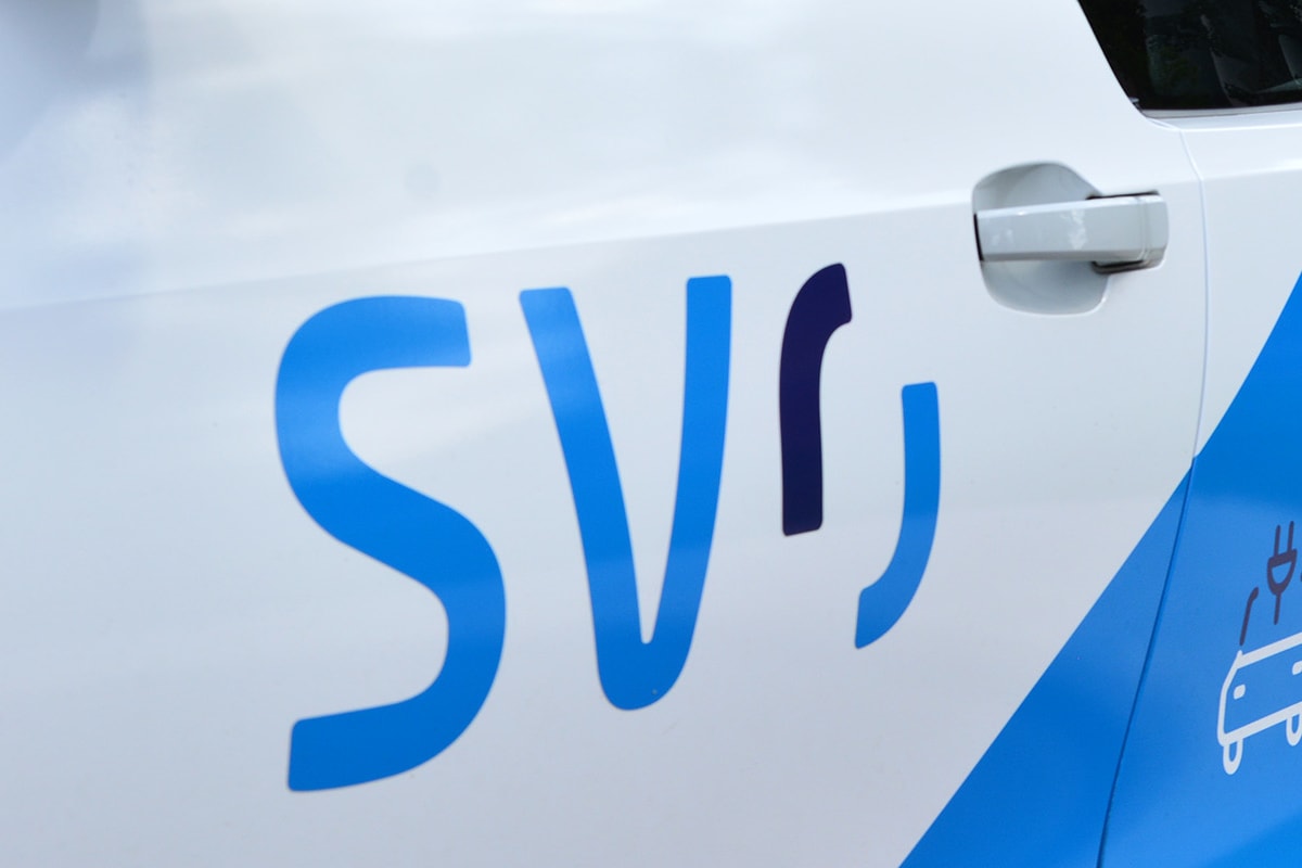 E-Auto mit SVO Logo parkt vor einer Ladesäule.
