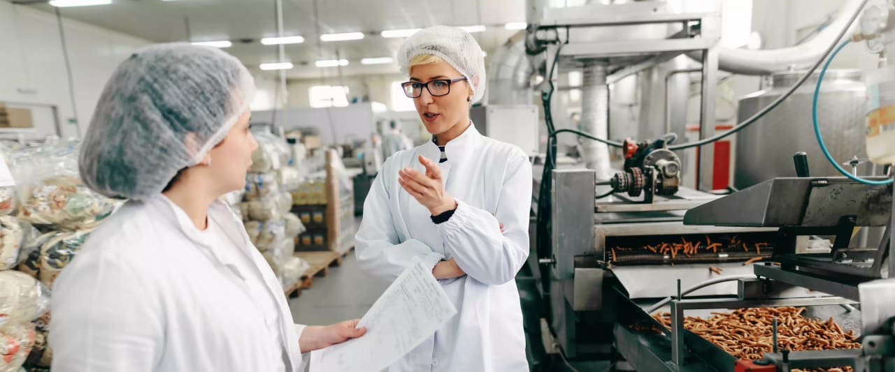 Zwei Frauen in einer Lebensmittelproduktionsanlage.