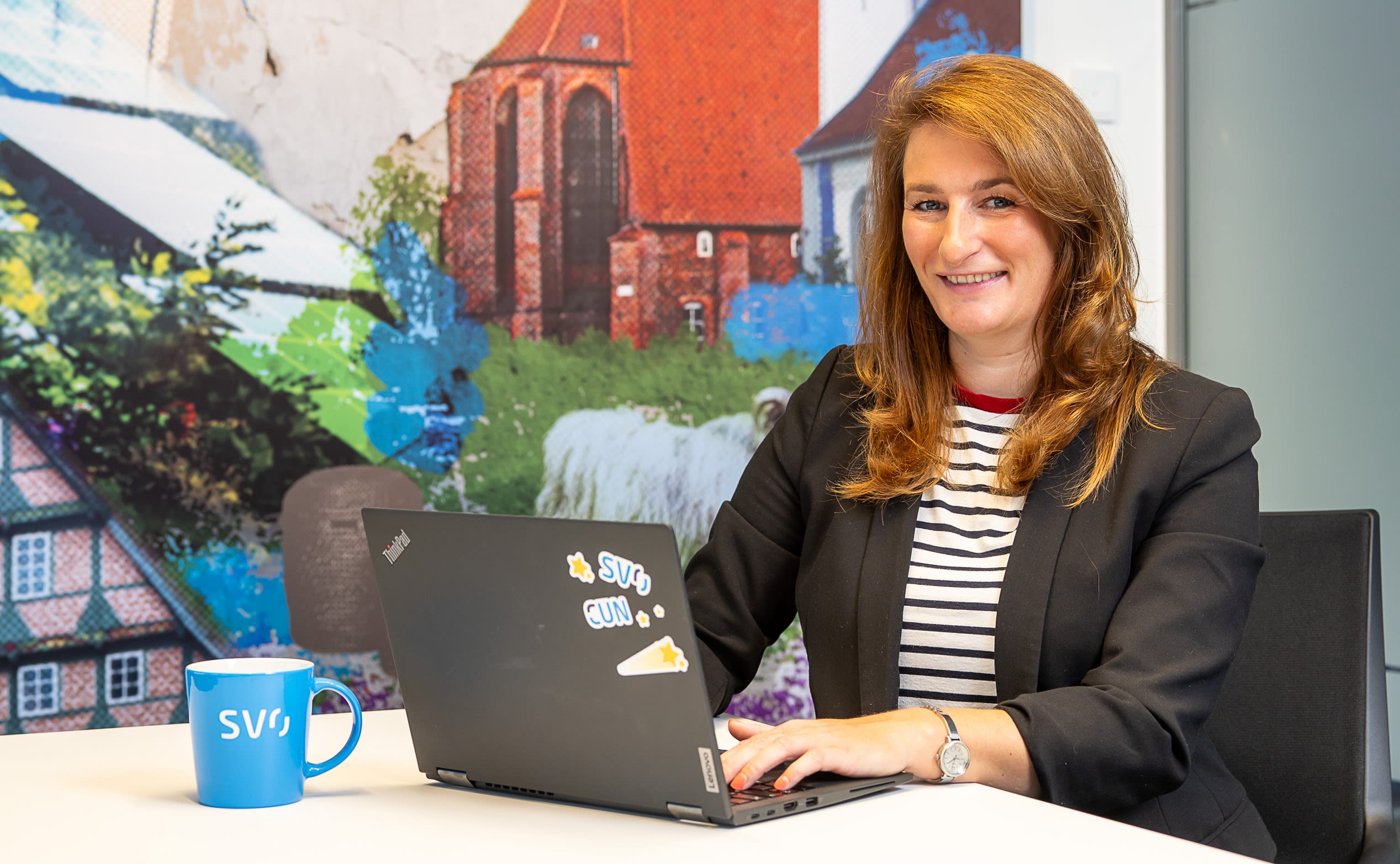Christin Gabriel sitzt mit Laptop am Schreibtisch