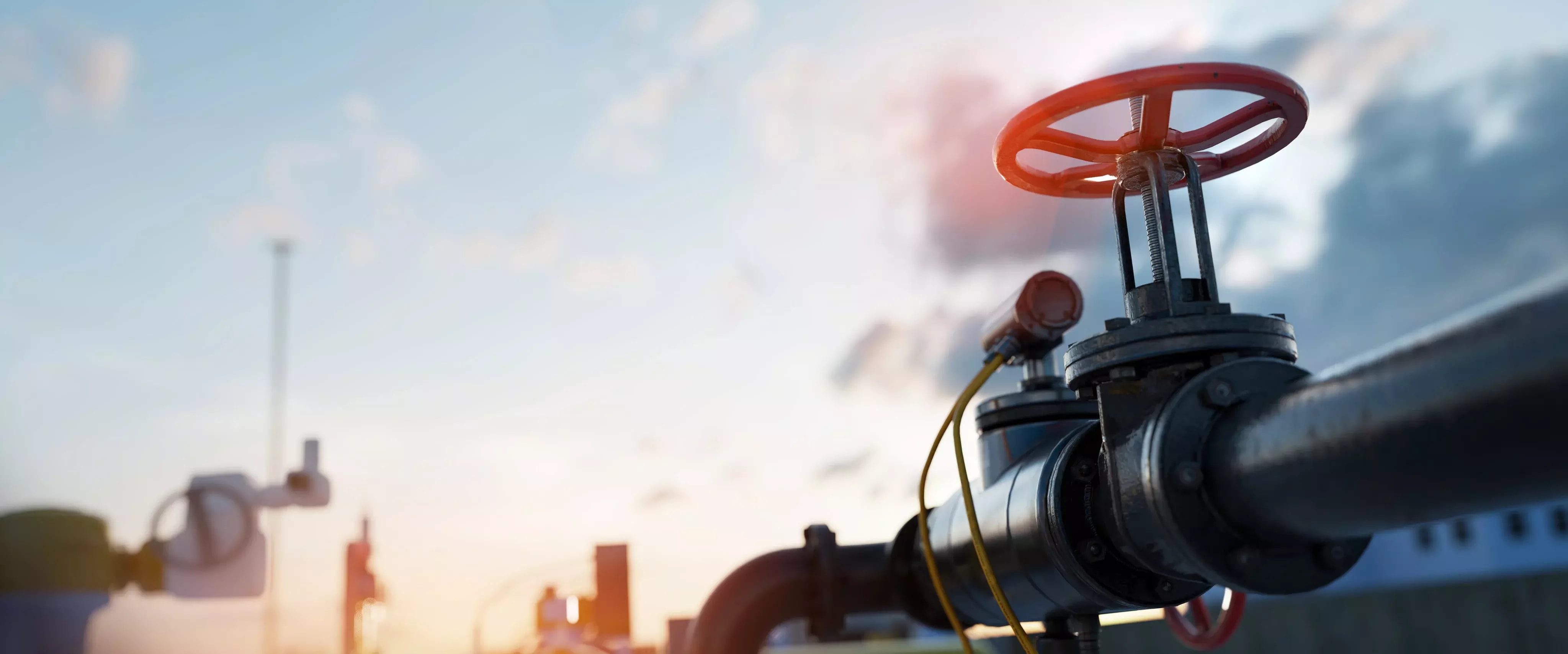 Ventil einer Gas-Pipeline im Fokus bei Sonnenuntergang.