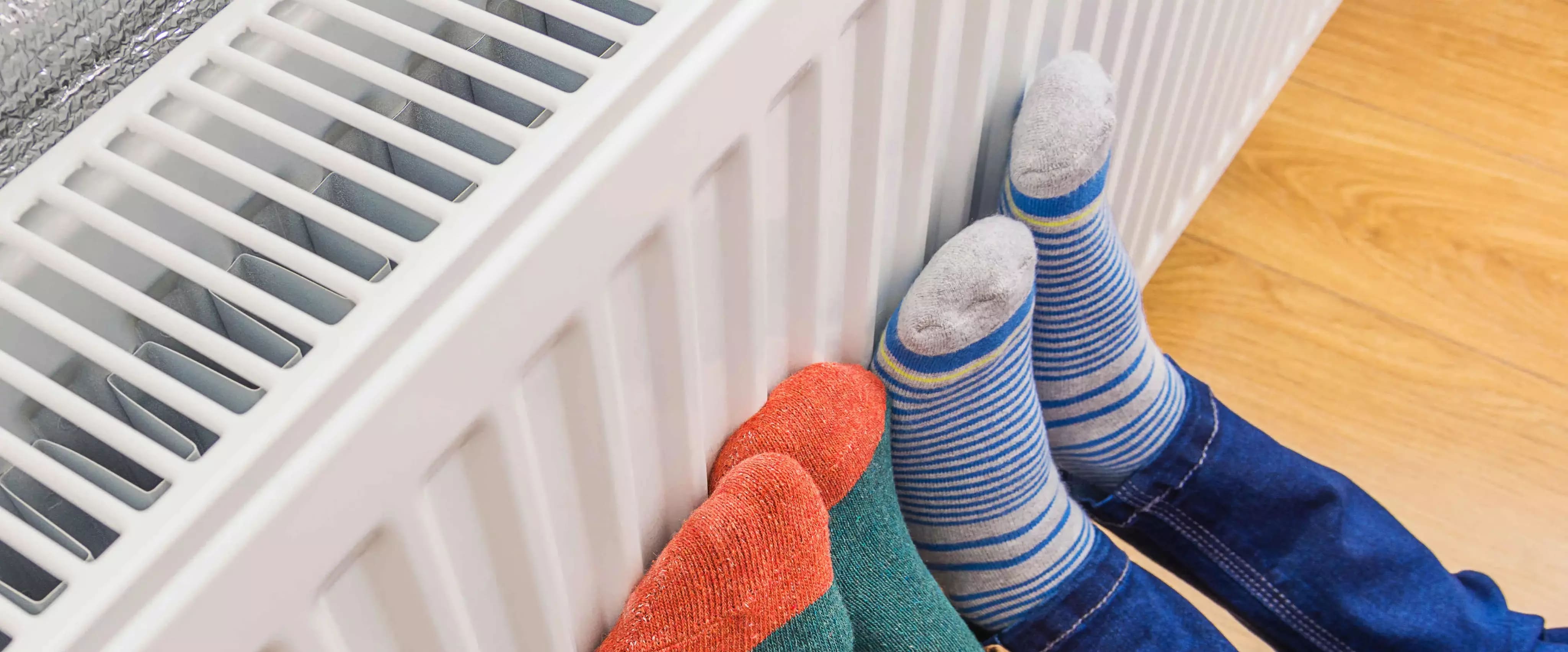 Füße wärmen sich an Heizkörper