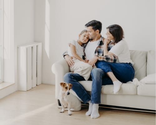 Auf dem Sofa sitzende Familie in ihrem Zuhause.