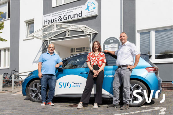Andreas Tiemann, Alina Brügge und Jan Stelzer posieren vor einem Elektorfahrzeug der SVO-Gruppe.