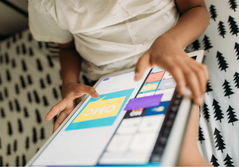 Kinderhände surfen an einem Tablet.