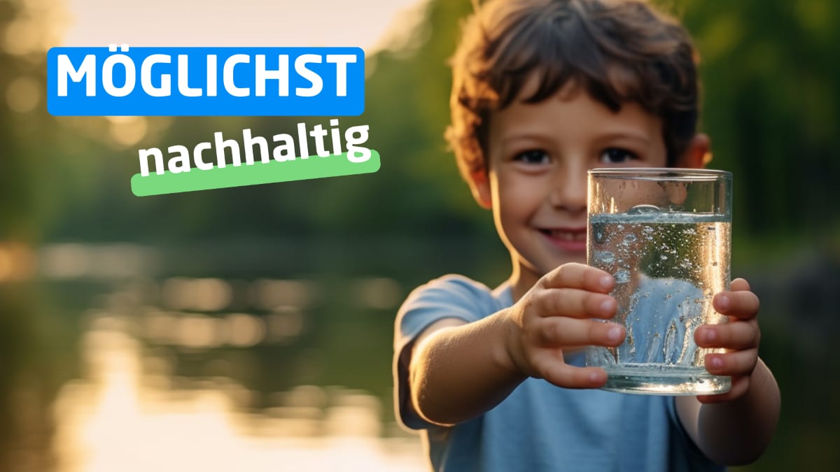 Ein kleiner Junge hält ein Glas Wasser in die Kamera.