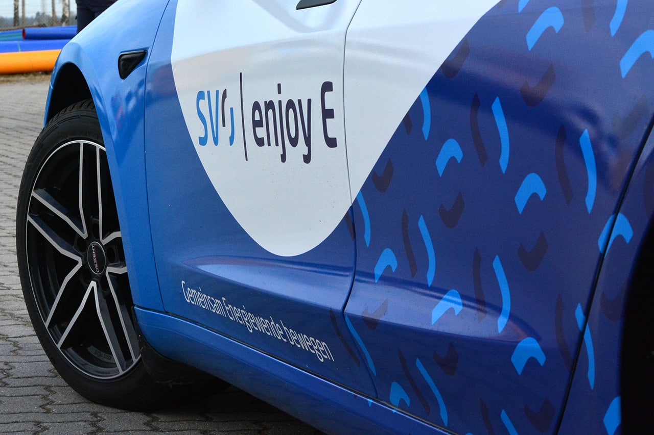 Auf der Fahrertür eines blauweißen Autos ist der Schriftzug 