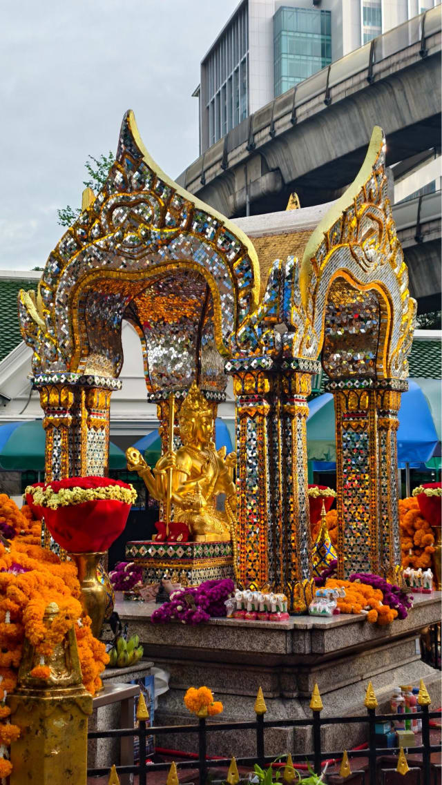 The Brahma shrine pavilion with the BTS Skytrain tracks visible behind it